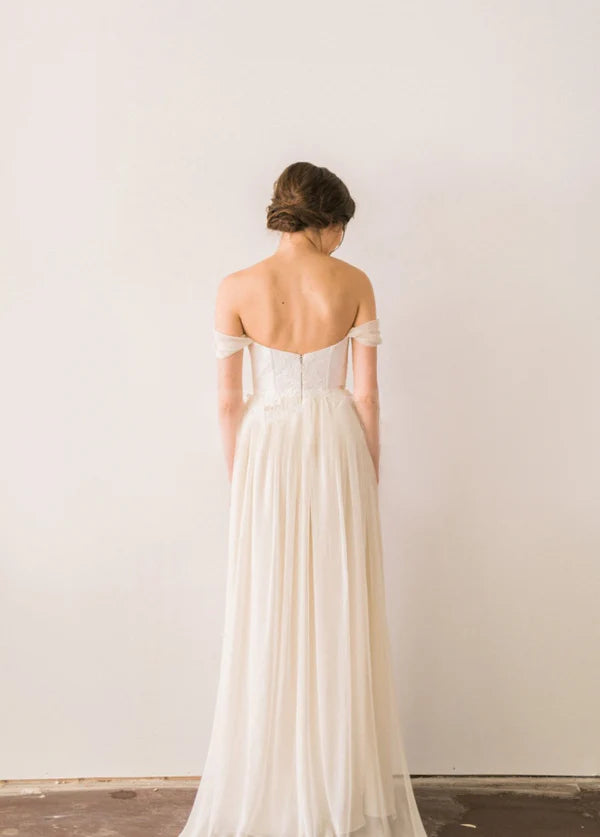 Back view of backless A-line chiffon wedding dress with flowing skirt.