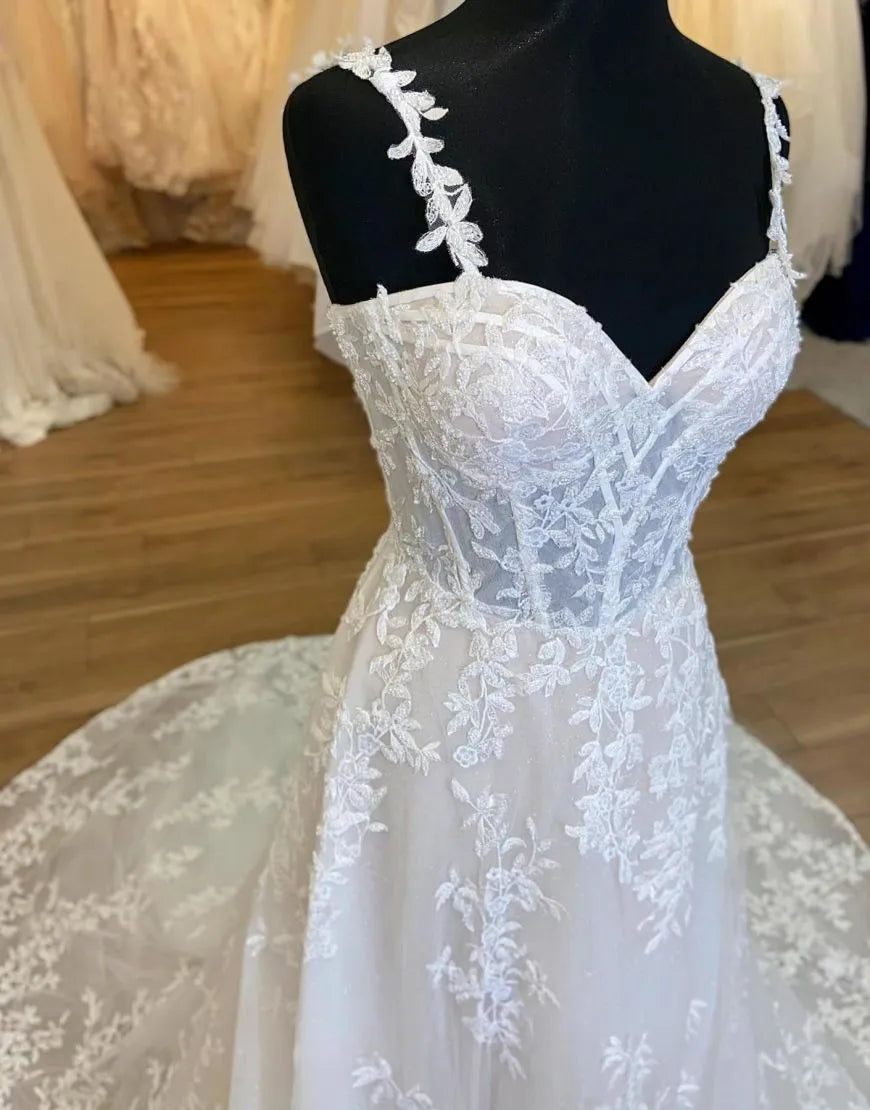 Front view of A-Line wedding dress with spaghetti straps and intricate appliques.