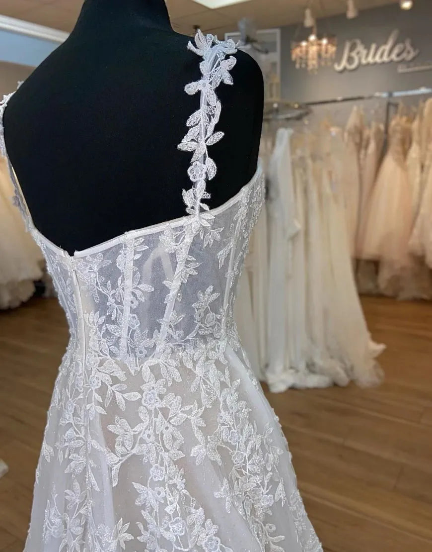 Side profile of A-Line bridal gown highlighting the flowing skirt and appliques.