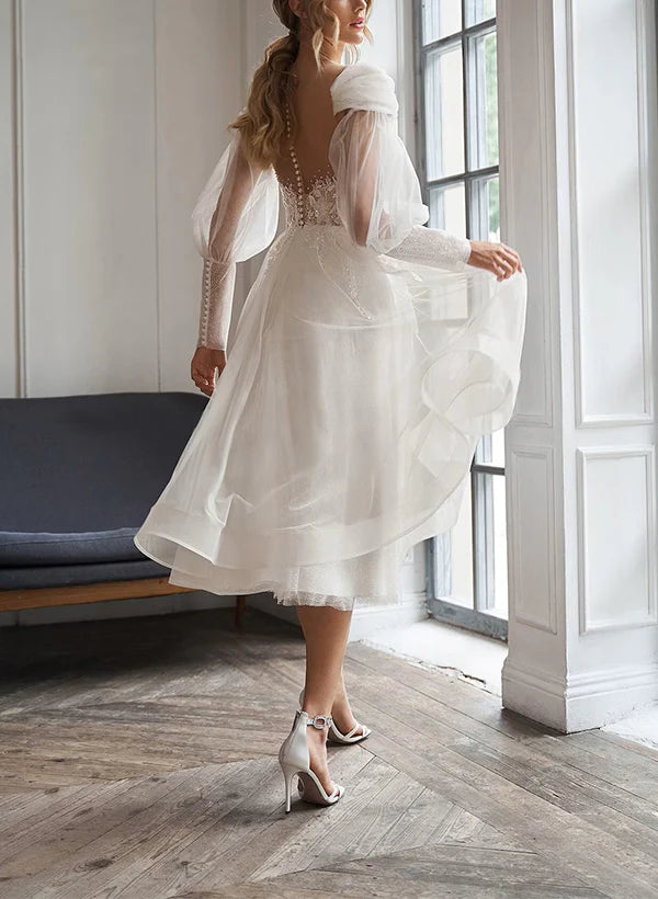 Back view of an elegant A-line tulle wedding gown with long sleeves.