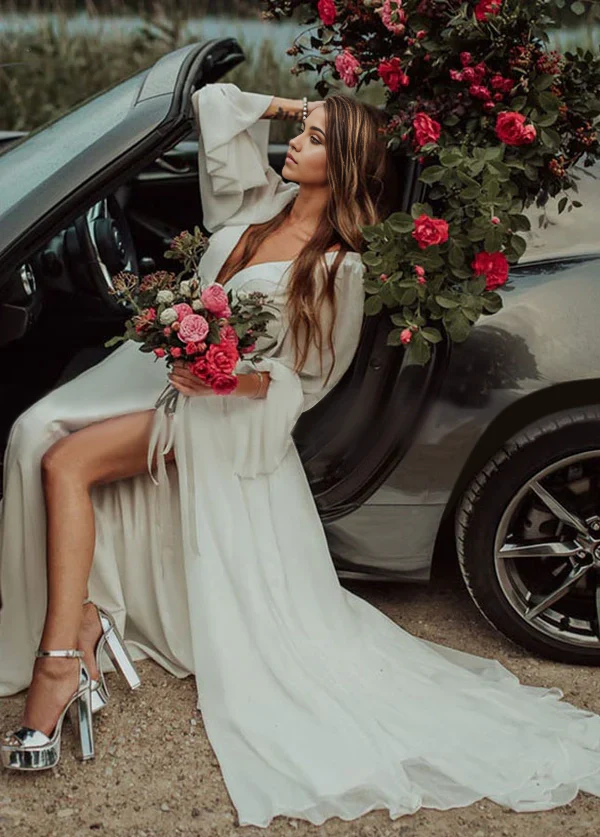 Side profile of the V-neck long-sleeve wedding gown, showcasing the flowing skirt.