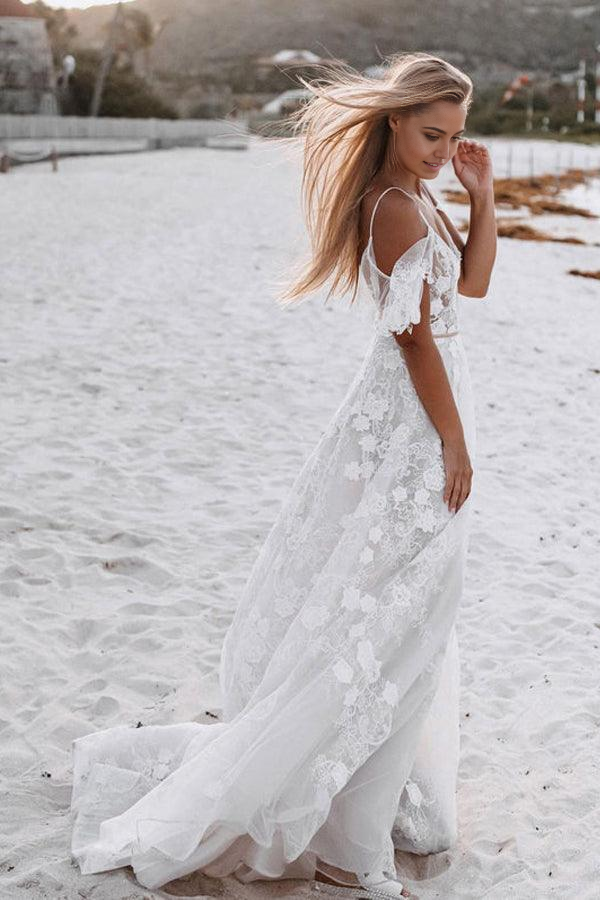 Back view of the romantic spaghetti strap wedding dress with a flowing skirt.
