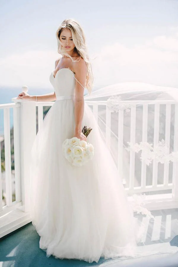 Ivory A-line wedding dress with sweetheart neckline and spaghetti straps.