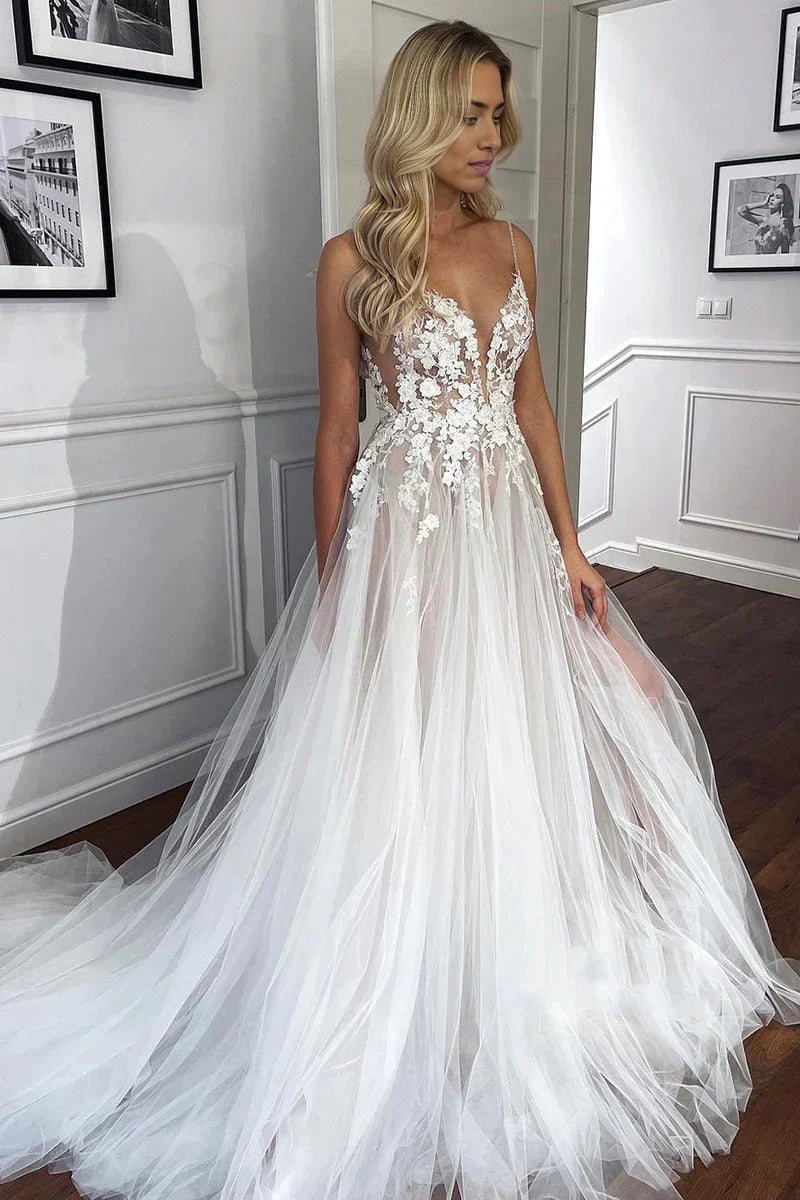 A-line wedding dress with spaghetti straps, V-neck, lace appliques, and tulle skirt.