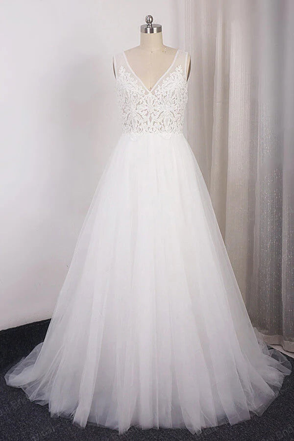 Model wearing an elegant A-line V-neck lace and tulle wedding dress with appliques.