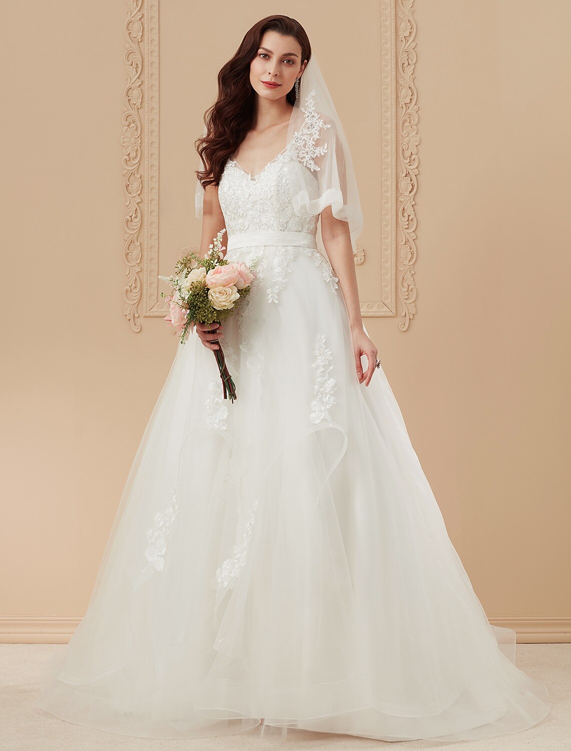 Romantic ball gown wedding dress with V-neck, spaghetti straps, and sweep train.