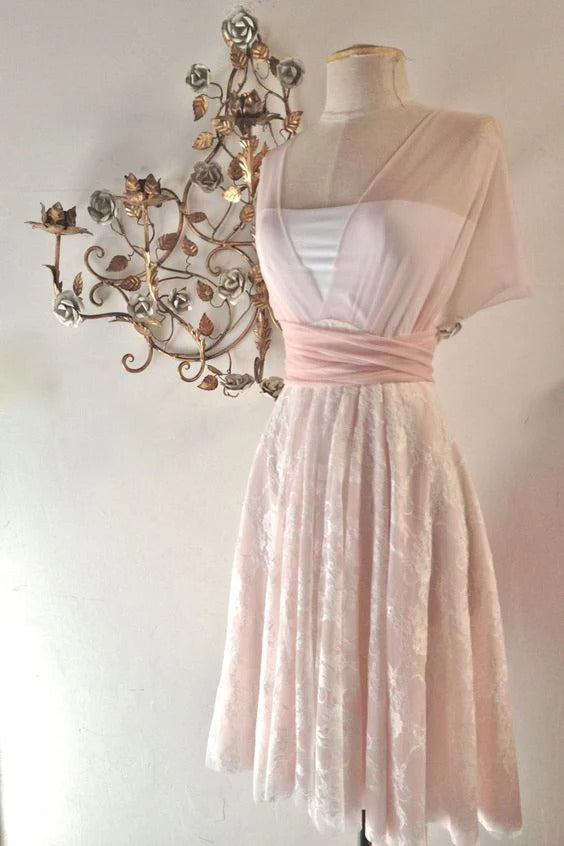 Model wearing a blush pink lace A-line dress with a square neckline and sheer short sleeves.