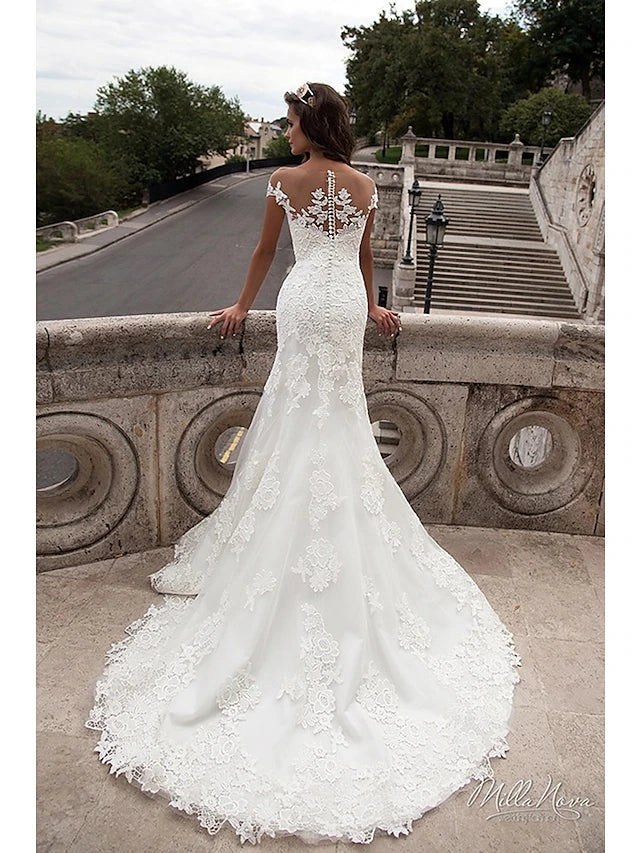 Close-up of lace appliques and off-shoulder cap sleeve on wedding gown.