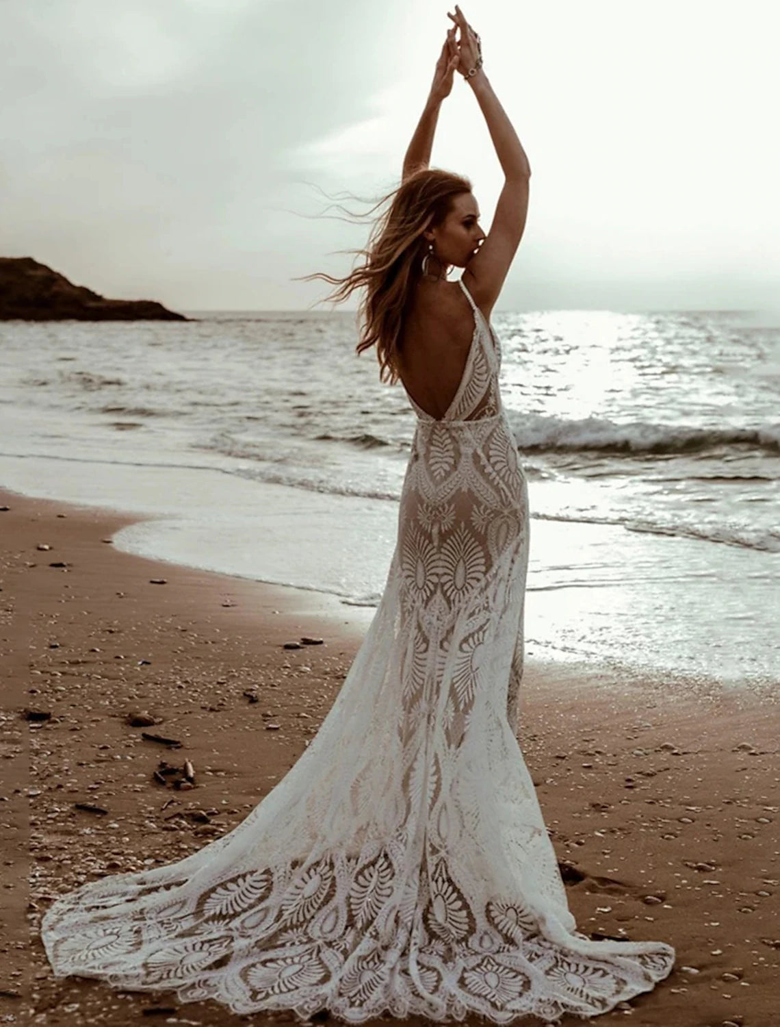 Romantic mermaid wedding dress with V-neck, open back, and sweep train.