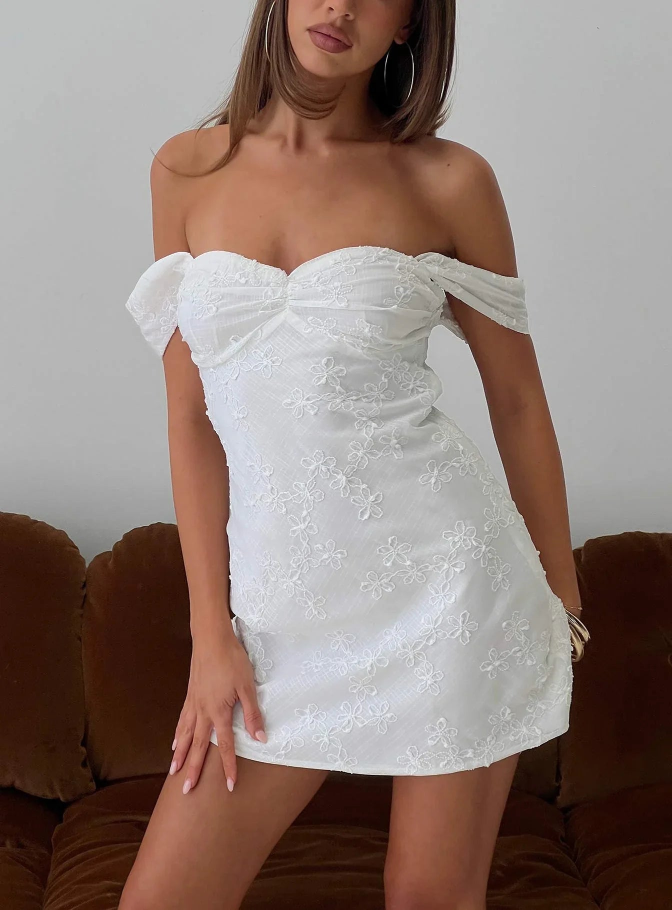 White off-shoulder mini homecoming dress with floral appliqué.