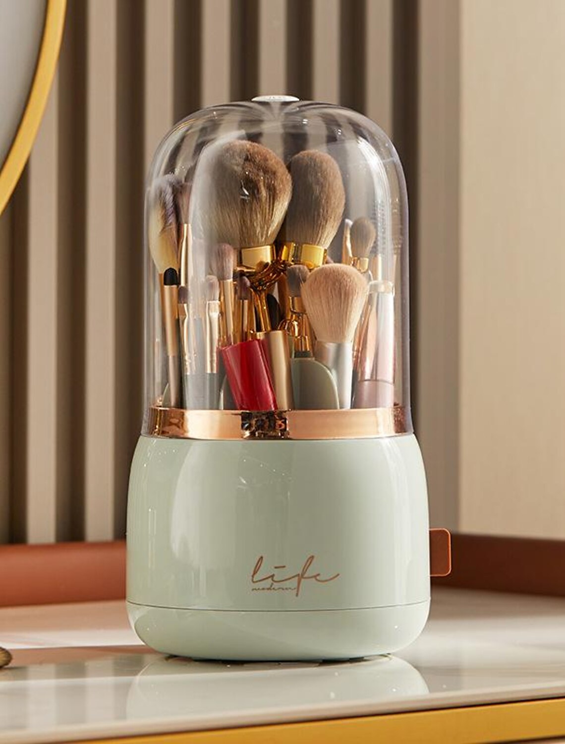Clear rotating makeup brush holder with a protective lid.