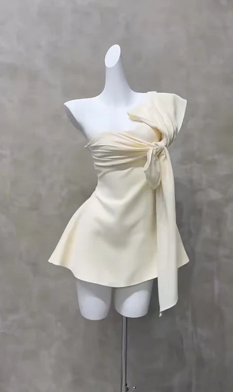 Model wearing a short A-line chiffon dress with an asymmetrical neckline.