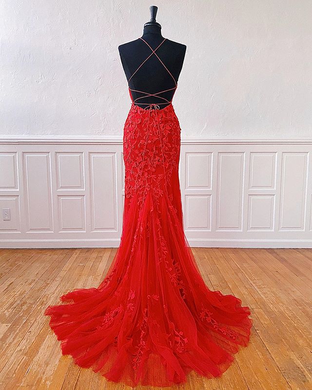 Back view of a long red lace prom dress with open back detail.