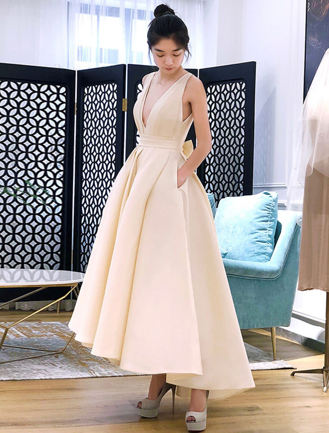 Woman wearing a champagne short fitted V-neck party dress.