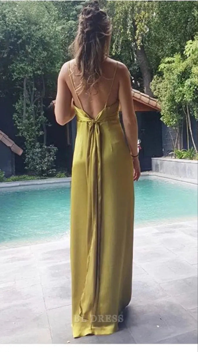 Woman wearing a long gold formal dress with spaghetti straps.