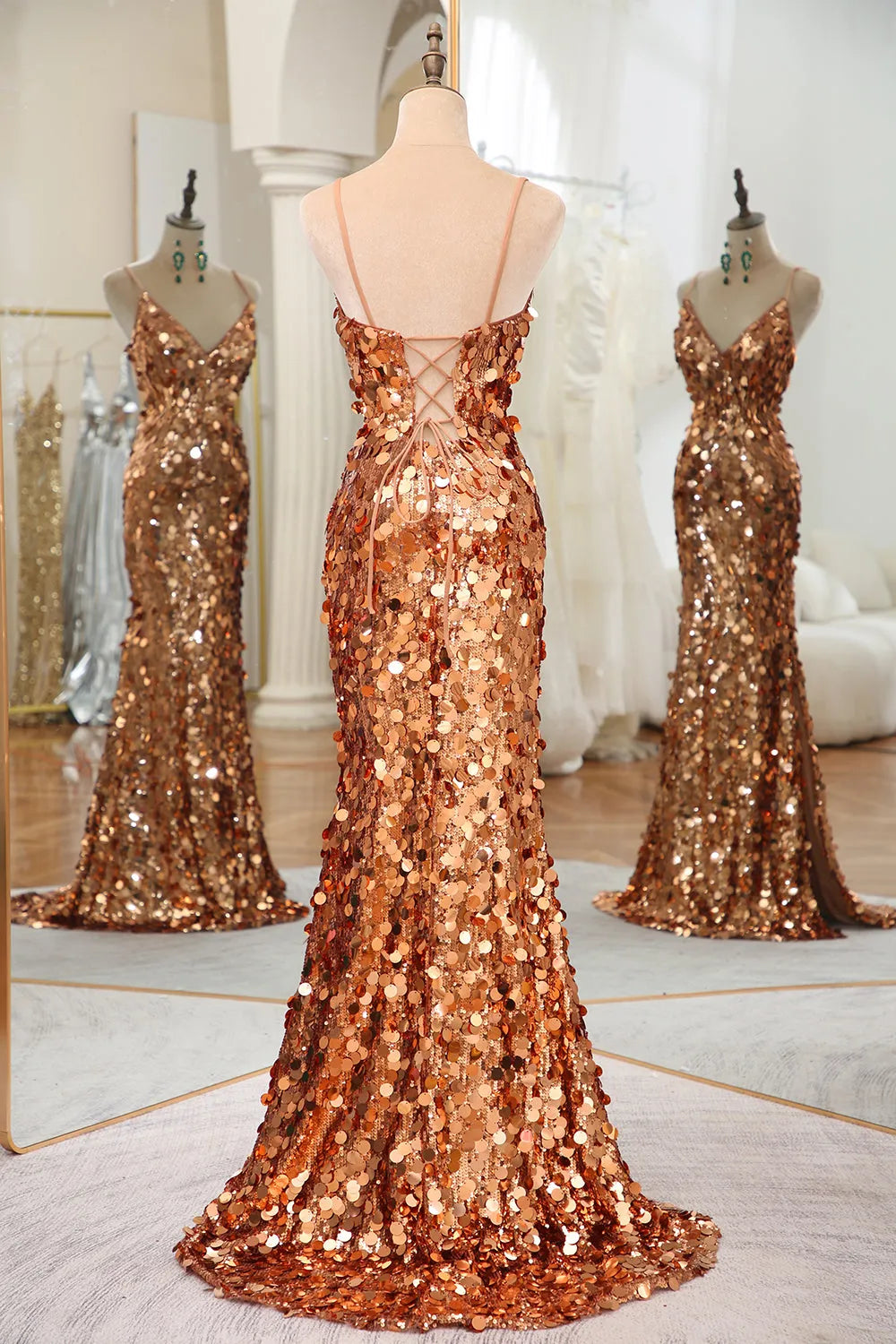 Back view of a woman in a rose gold sequin mermaid dress, showcasing the long train.