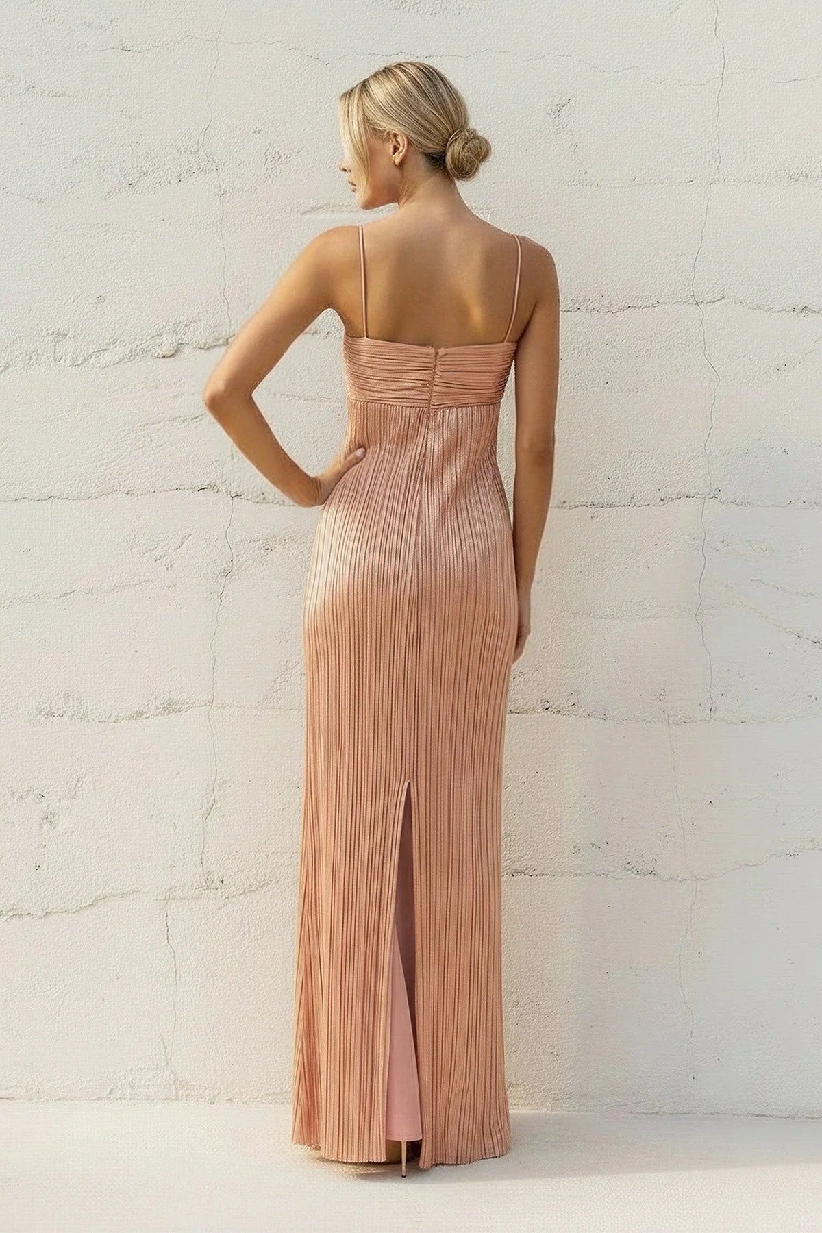 Back view of the metallic pleated formal gown showing the subtle back slit.