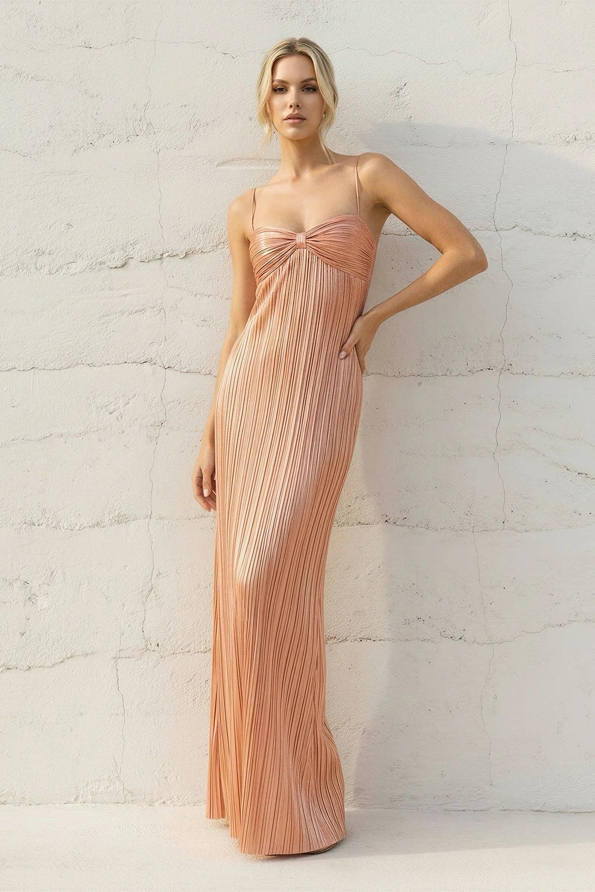 Close-up of the sweetheart neckline and bow detail on the metallic pleated dress.