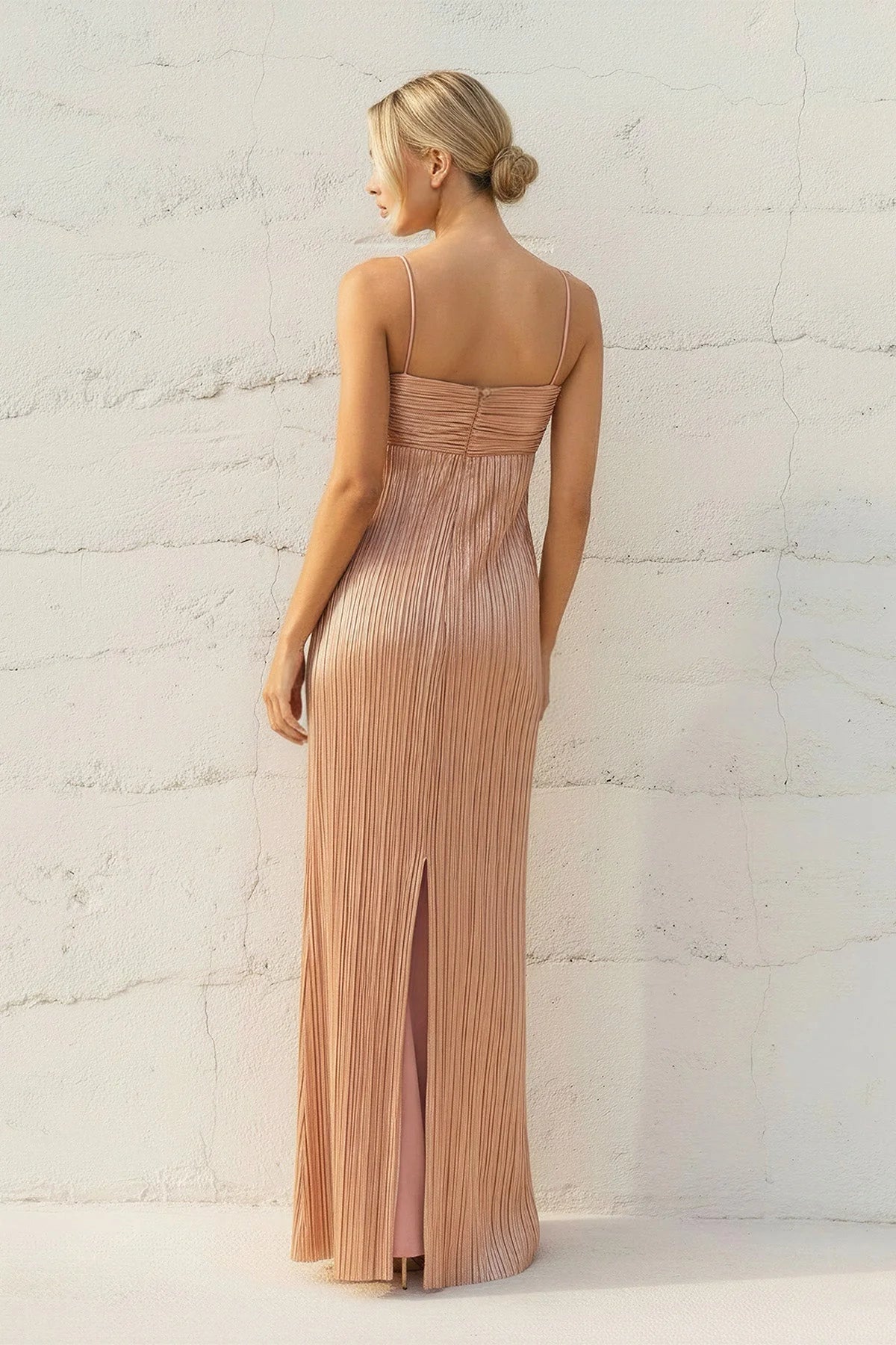 Side view of the elegant metallic pleated gown, highlighting its form-fitting silhouette.