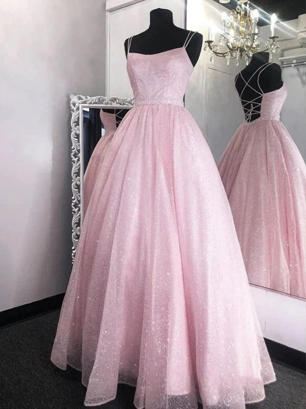 Woman wearing a sparkling sequin backless maxi prom gown.
