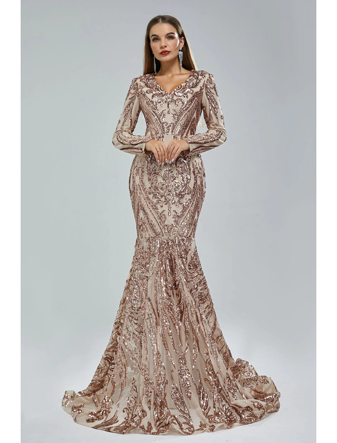 Woman wearing a shimmering V-neck long sleeve mermaid evening gown with sequin lace and a court train.