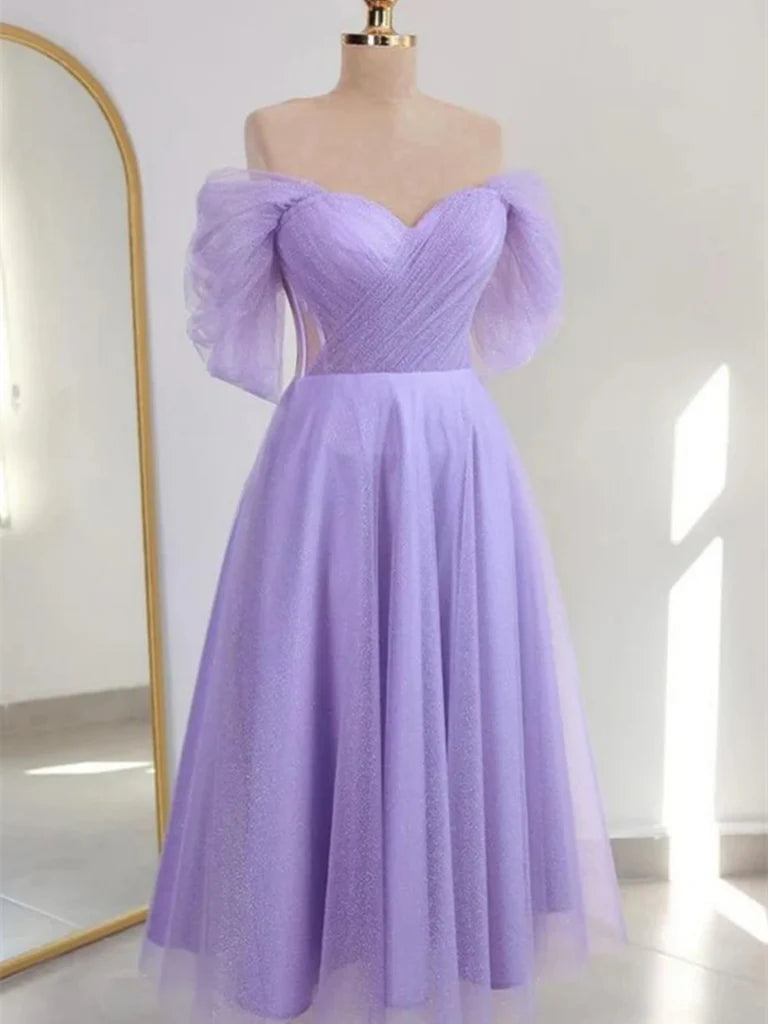 Back view of a model in a shiny off-the-shoulder A-line dress.