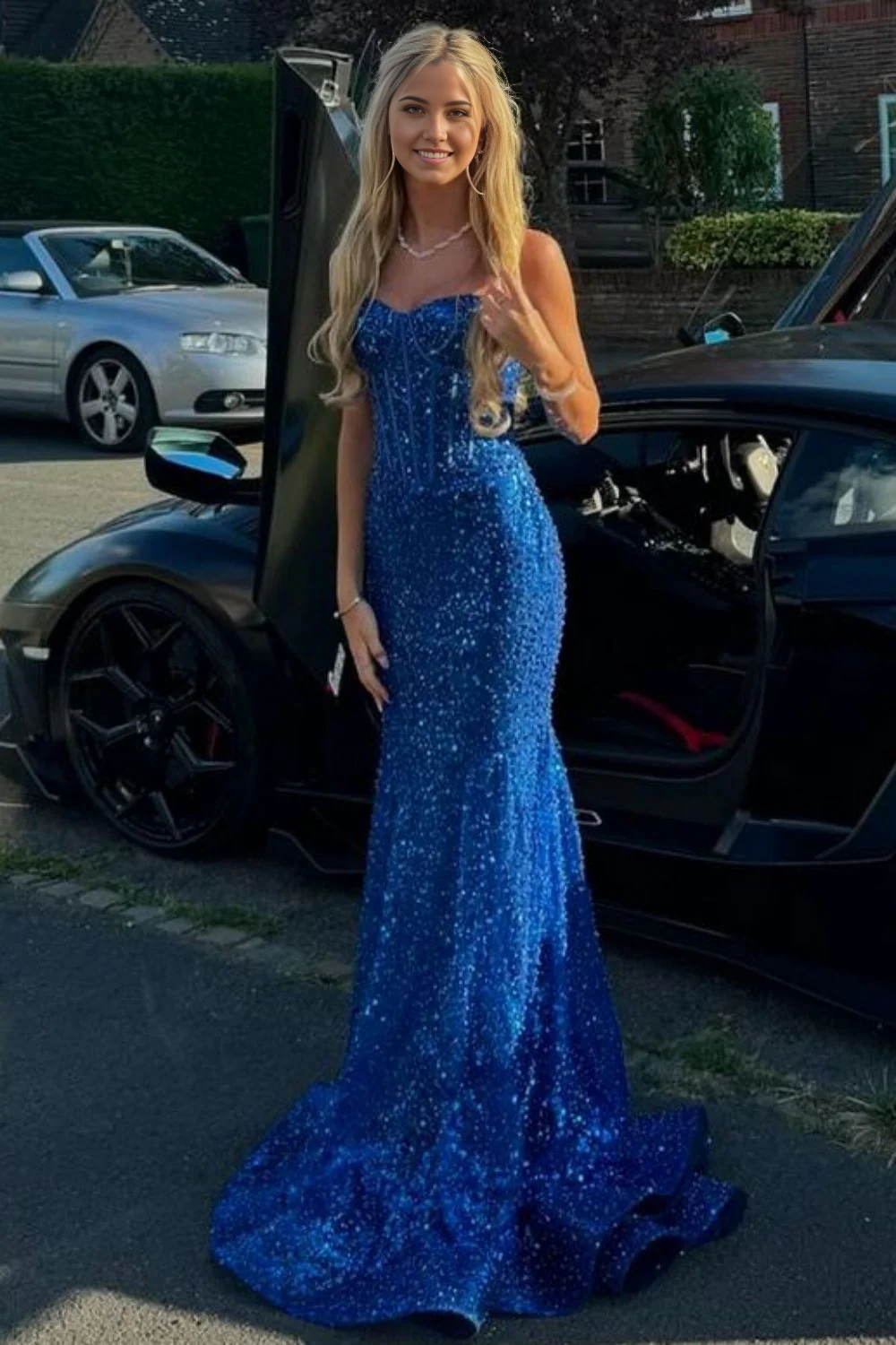 Model wearing a light blue mermaid prom dress with shiny beading.
