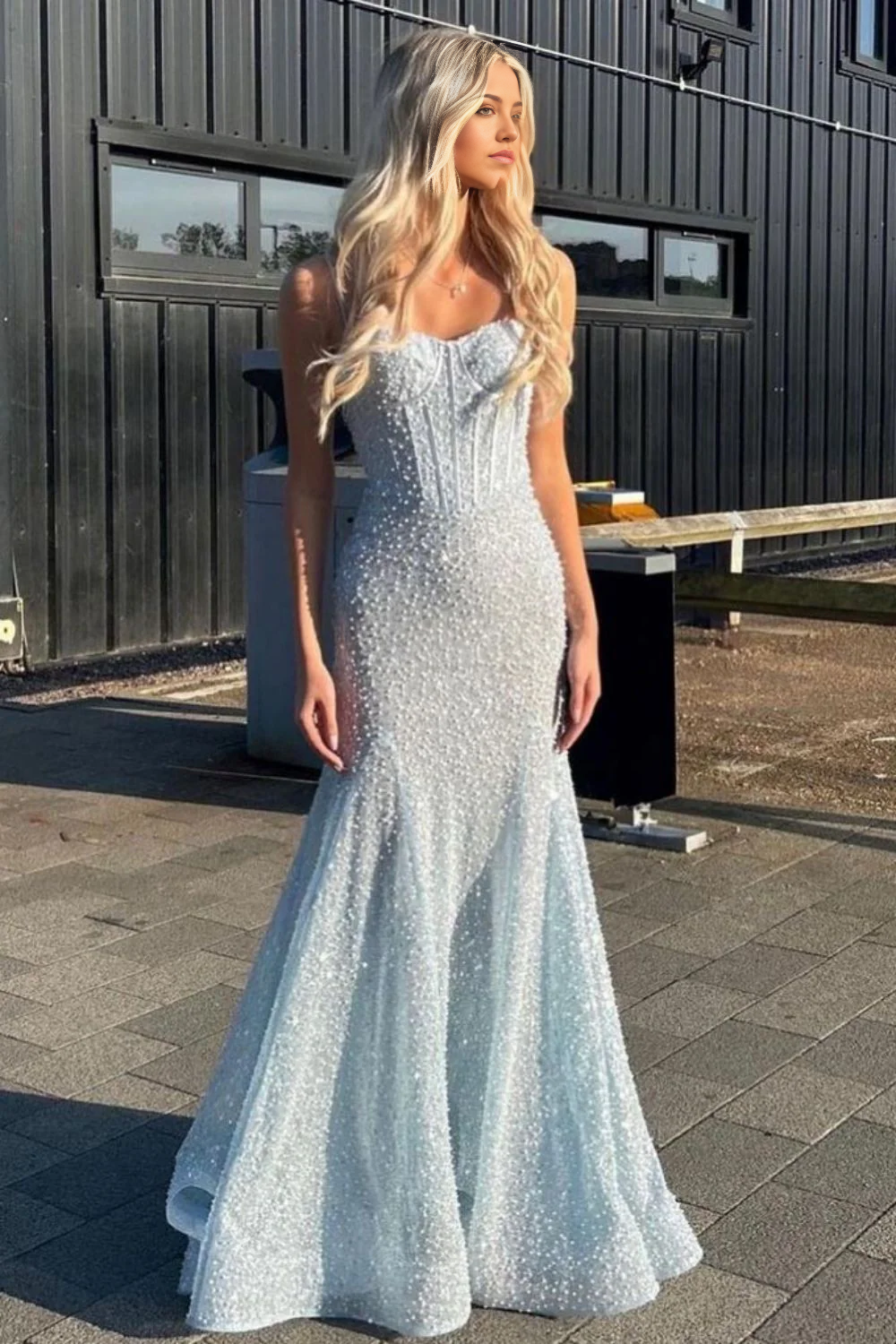 Side view of a model in a light blue beaded mermaid prom dress.