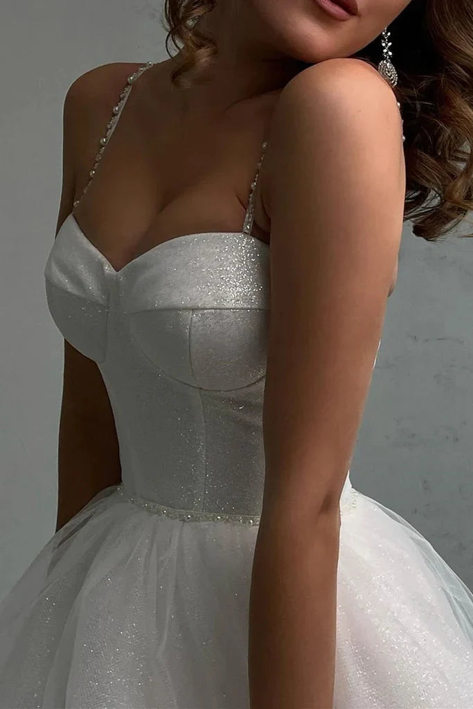 Back view of a woman wearing a shiny tulle A-line long prom dress.