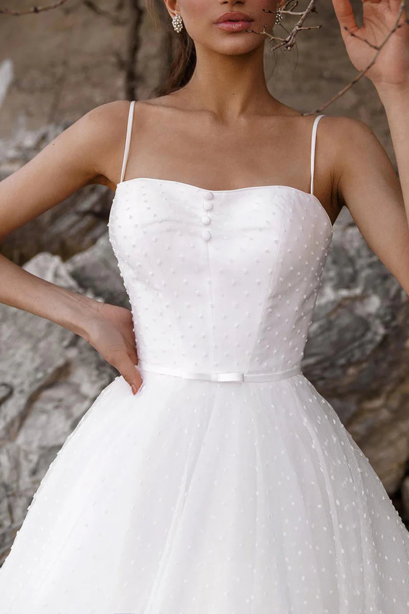 Close-up of the spaghetti straps and low neckline on the A-line wedding dress.