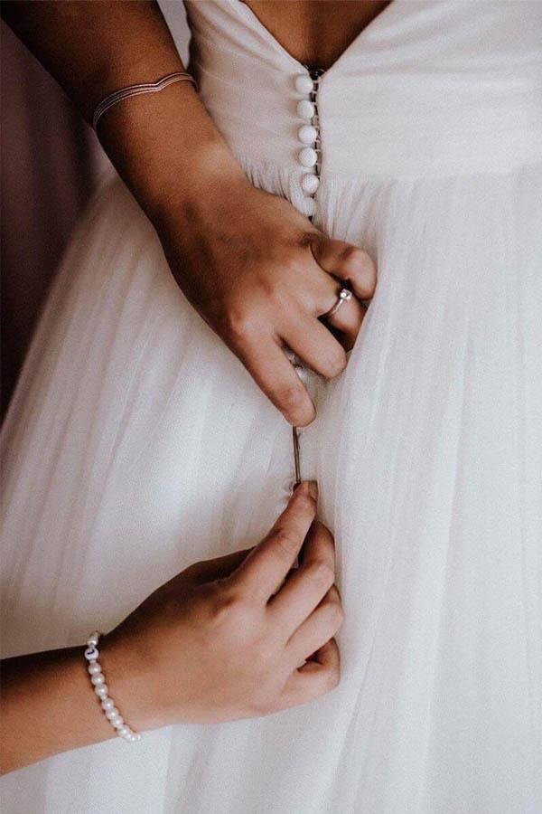 Close-up of the ivory tulle fabric and V-neckline on a wedding dress.
