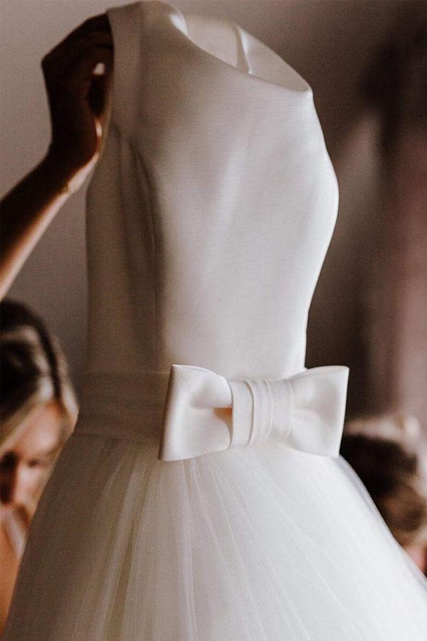 Full length view of a simple A-line ivory wedding dress with a flowing skirt.