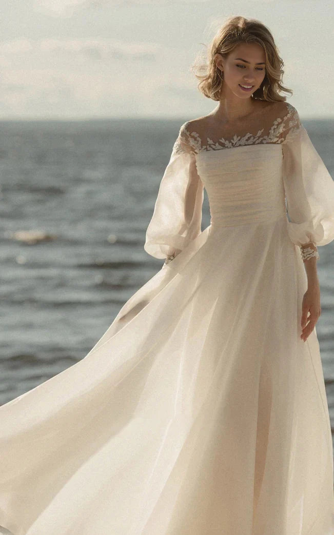 Full view of an A-line wedding dress with sheer sleeves and a V-neckline.