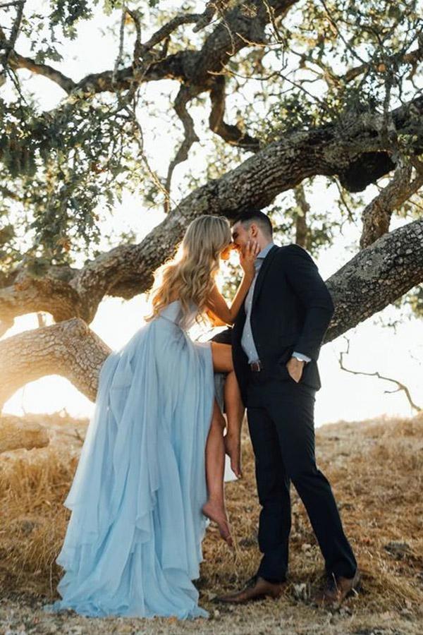 Full length view of a sky blue A-line V-neck wedding dress with a split, suitable for a beach wedding.