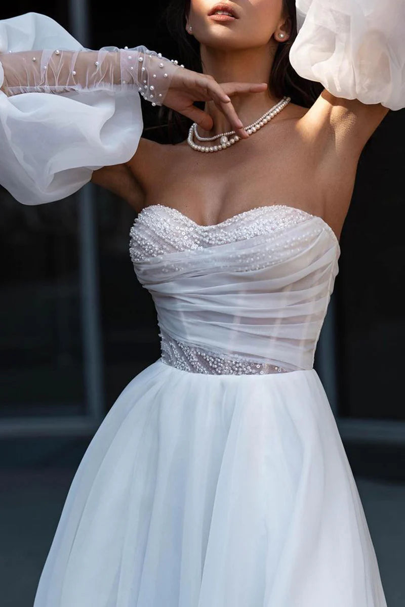 Close-up of pearl embellishments on a sleeveless wedding dress.