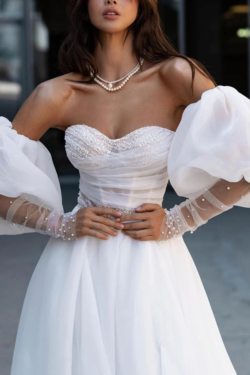 Back view of a sleeveless A-line wedding gown with pearl accents.