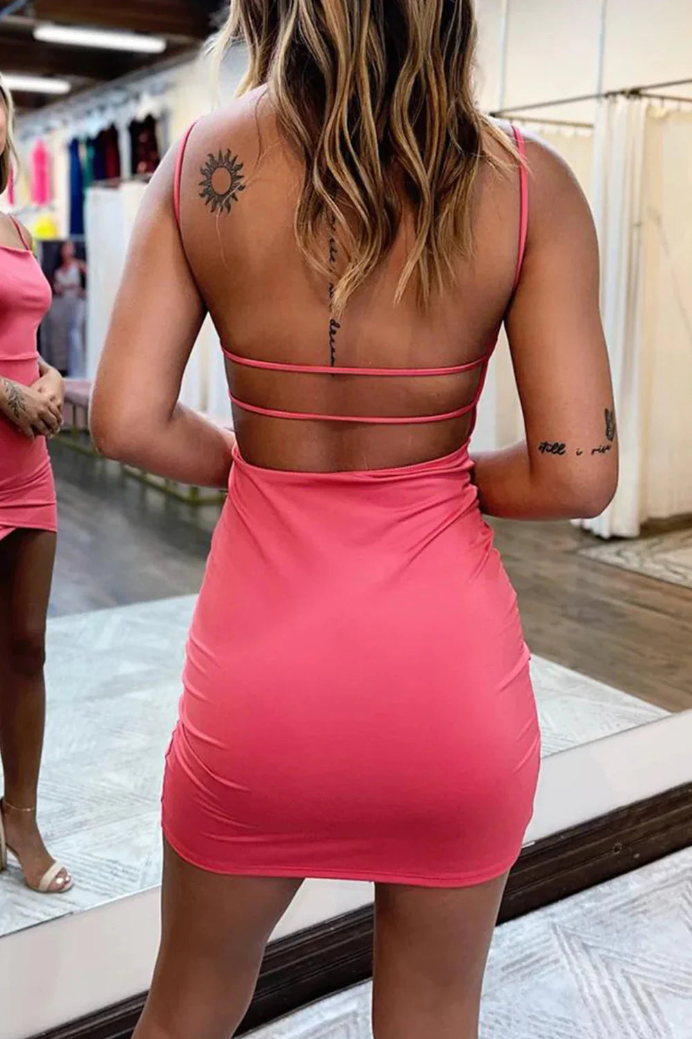 Back view of a black sleeveless bodycon mini dress showing the open back detail.