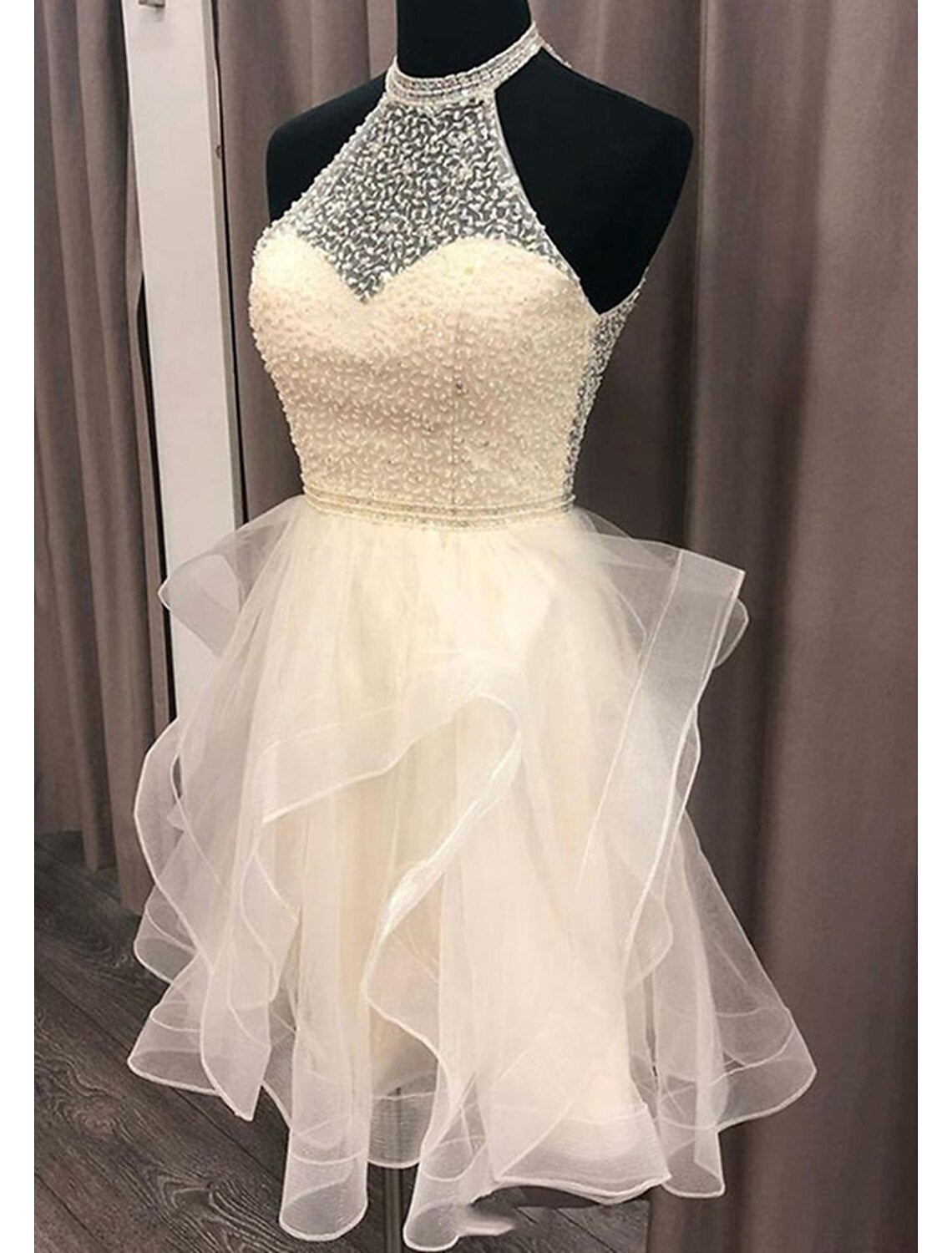 Back view of a backless halter homecoming dress with sparkling organza.