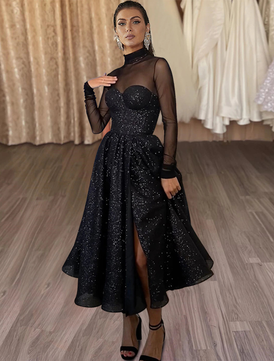 Model wearing a sparkling A-line high neck long sleeve tea length glitter tulle dress.