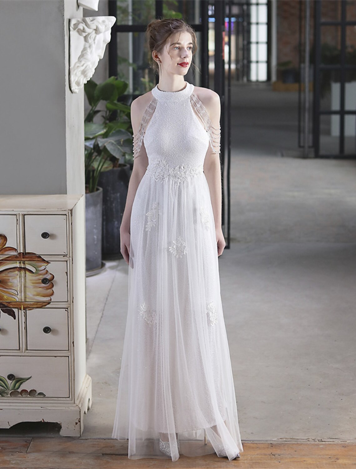Woman posing in a short sleeve, floor-length sequin dress.