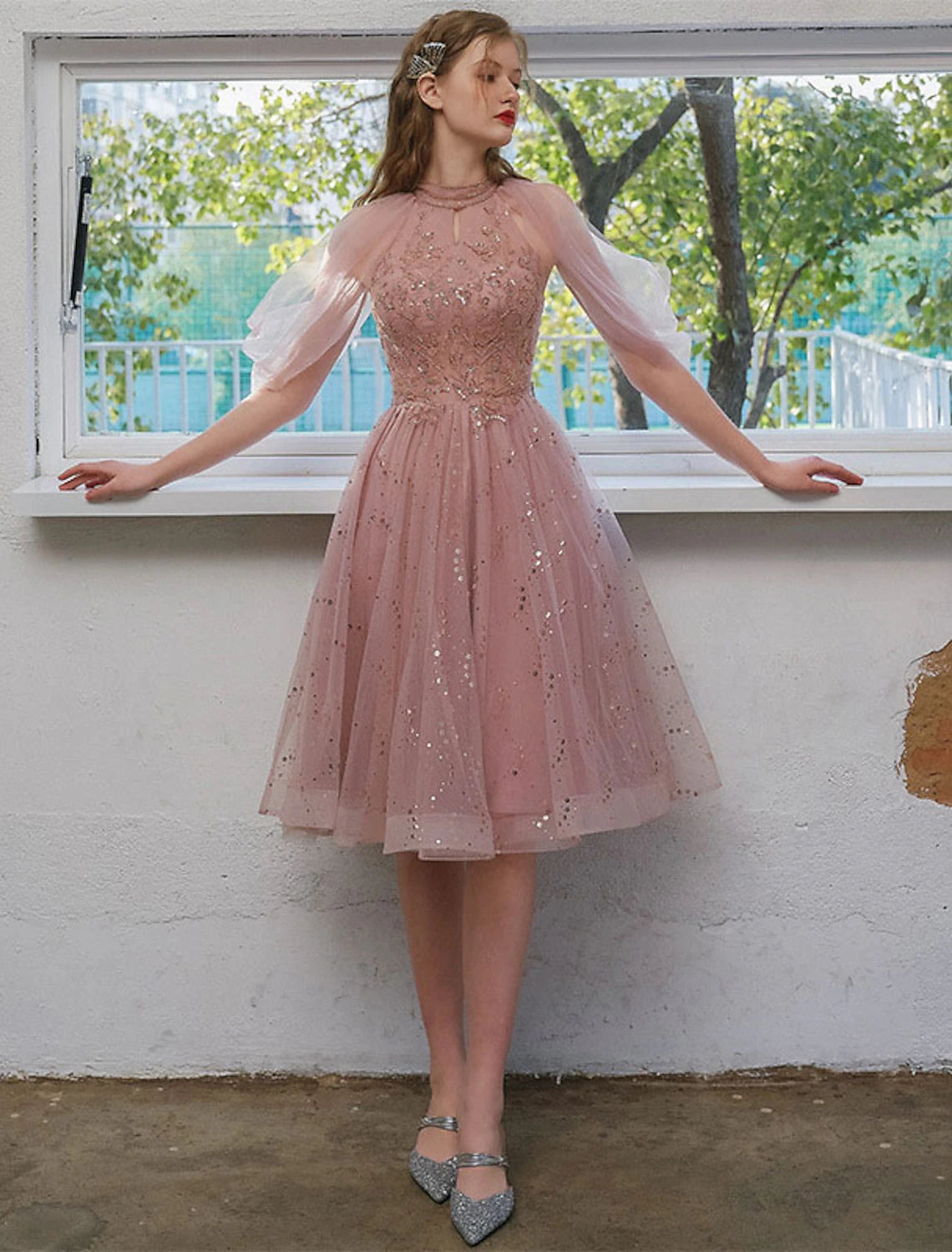 Model wearing A-Line sequin tulle cocktail dress with jewel neck and 3/4 sleeves.