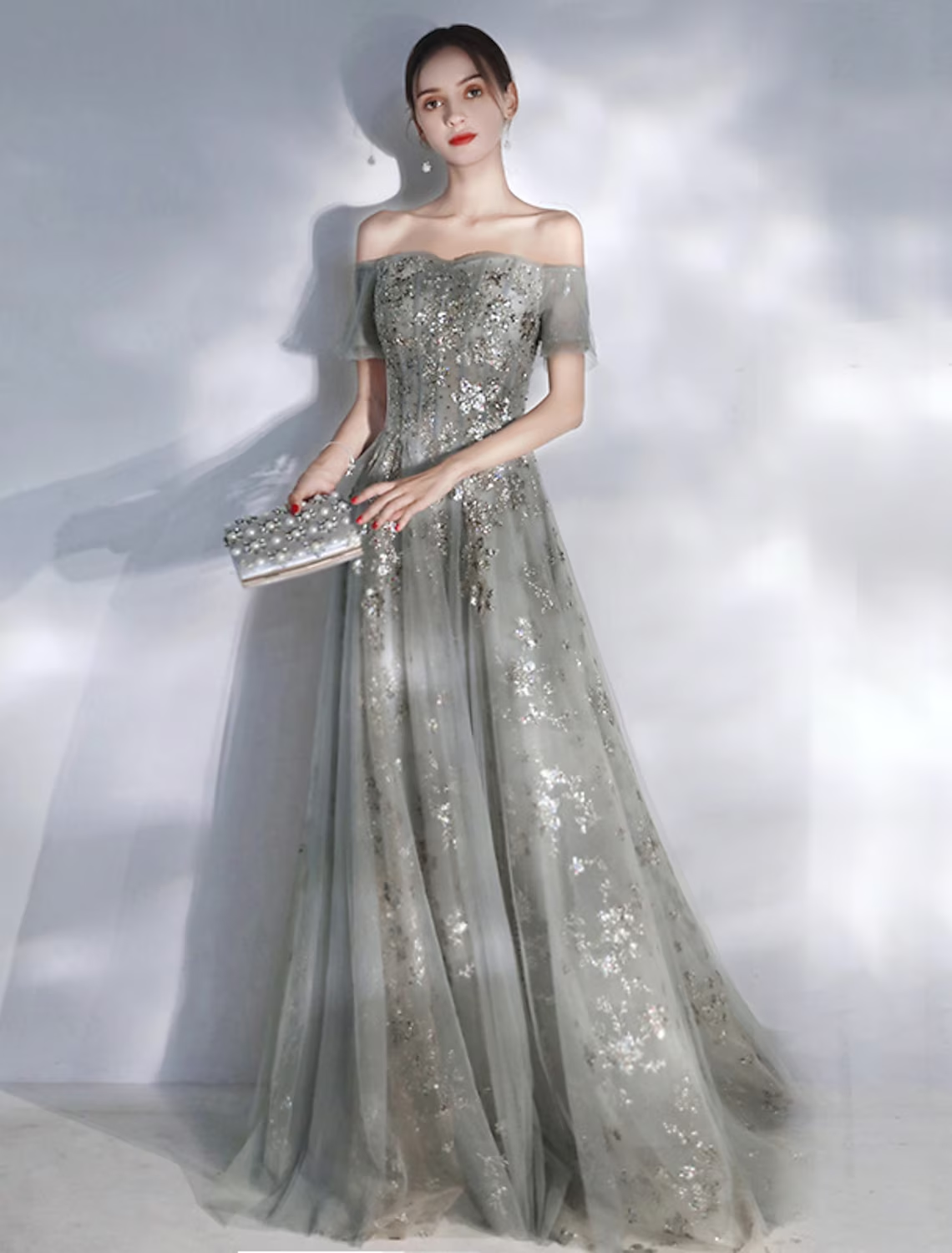 Model wearing a sparkling A-line off-shoulder floor-length evening gown with sequin appliques.