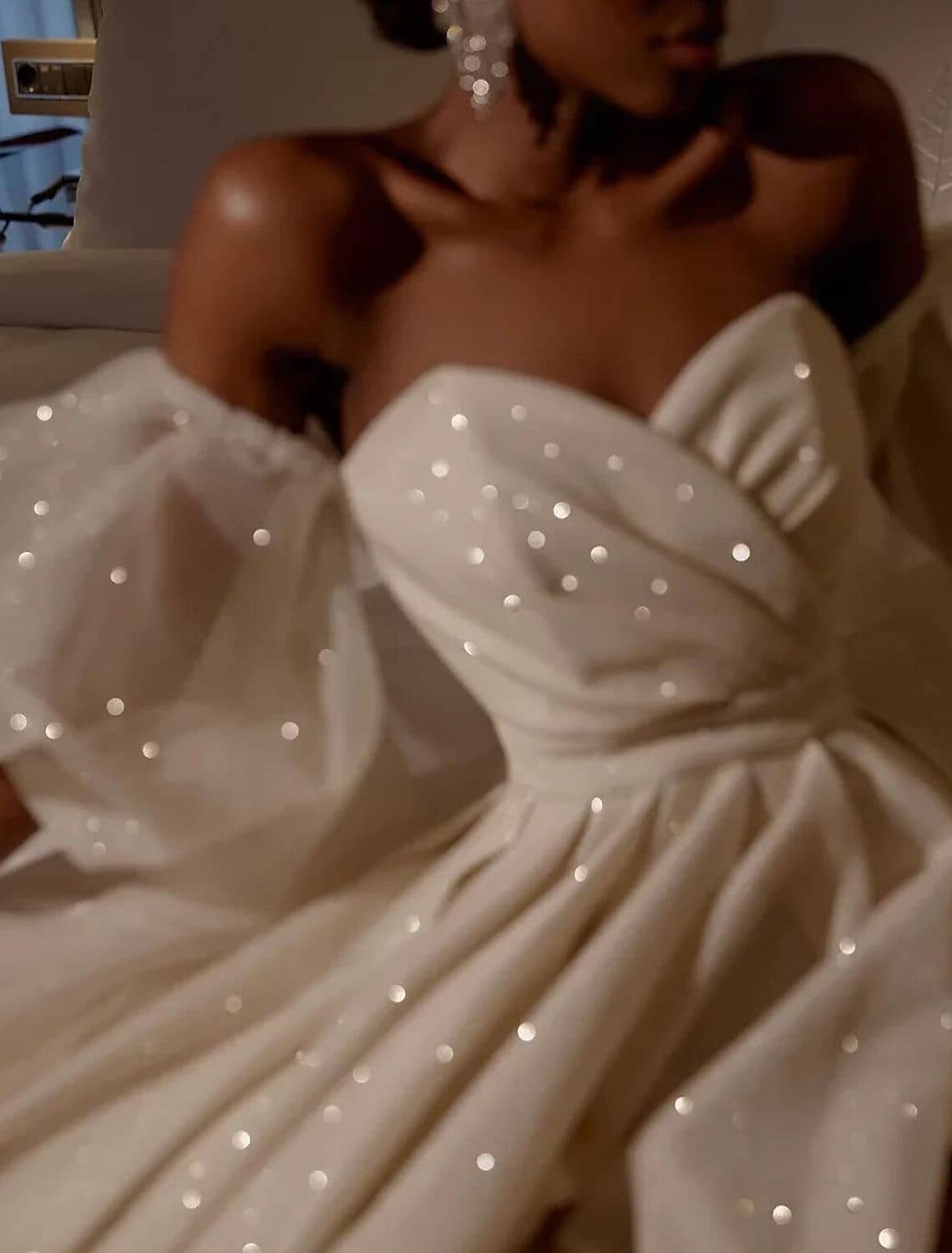 Close-up of the sequin detailing on the off-shoulder wedding gown.