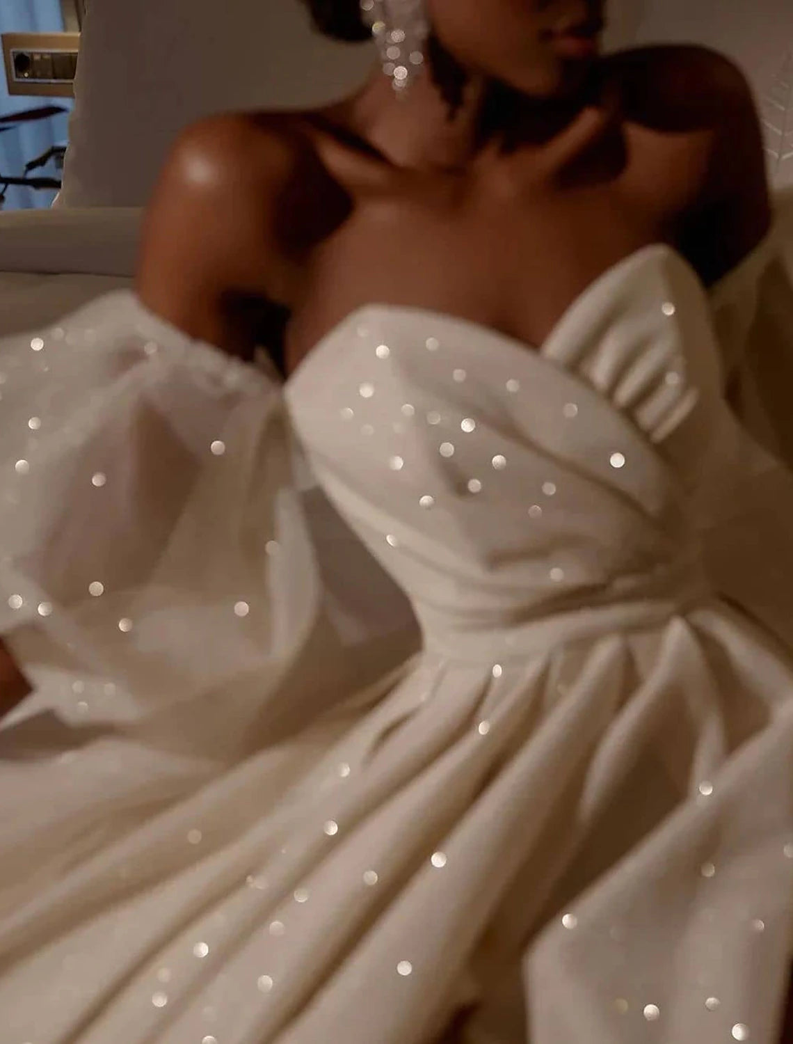 Side profile of the floor-length sequined wedding dress.