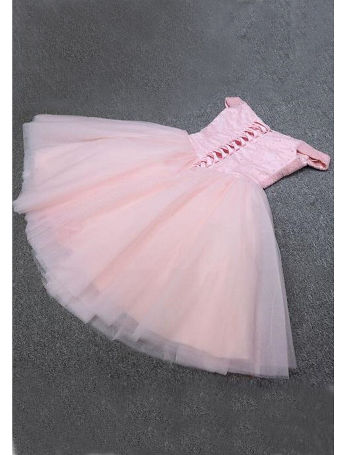 Model wearing a sparkling A-line off-shoulder sequin tulle knee-length homecoming dress, side view.