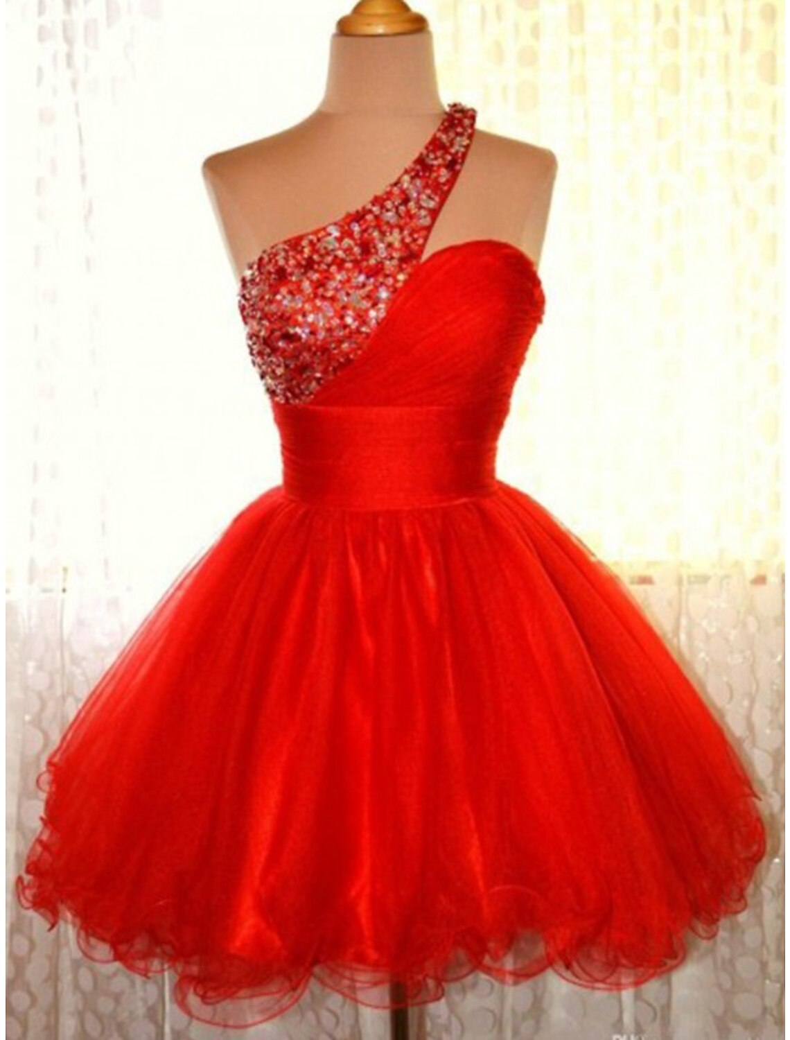 Model wearing a sparkling pink A-line one-shoulder mini homecoming dress with sequins.