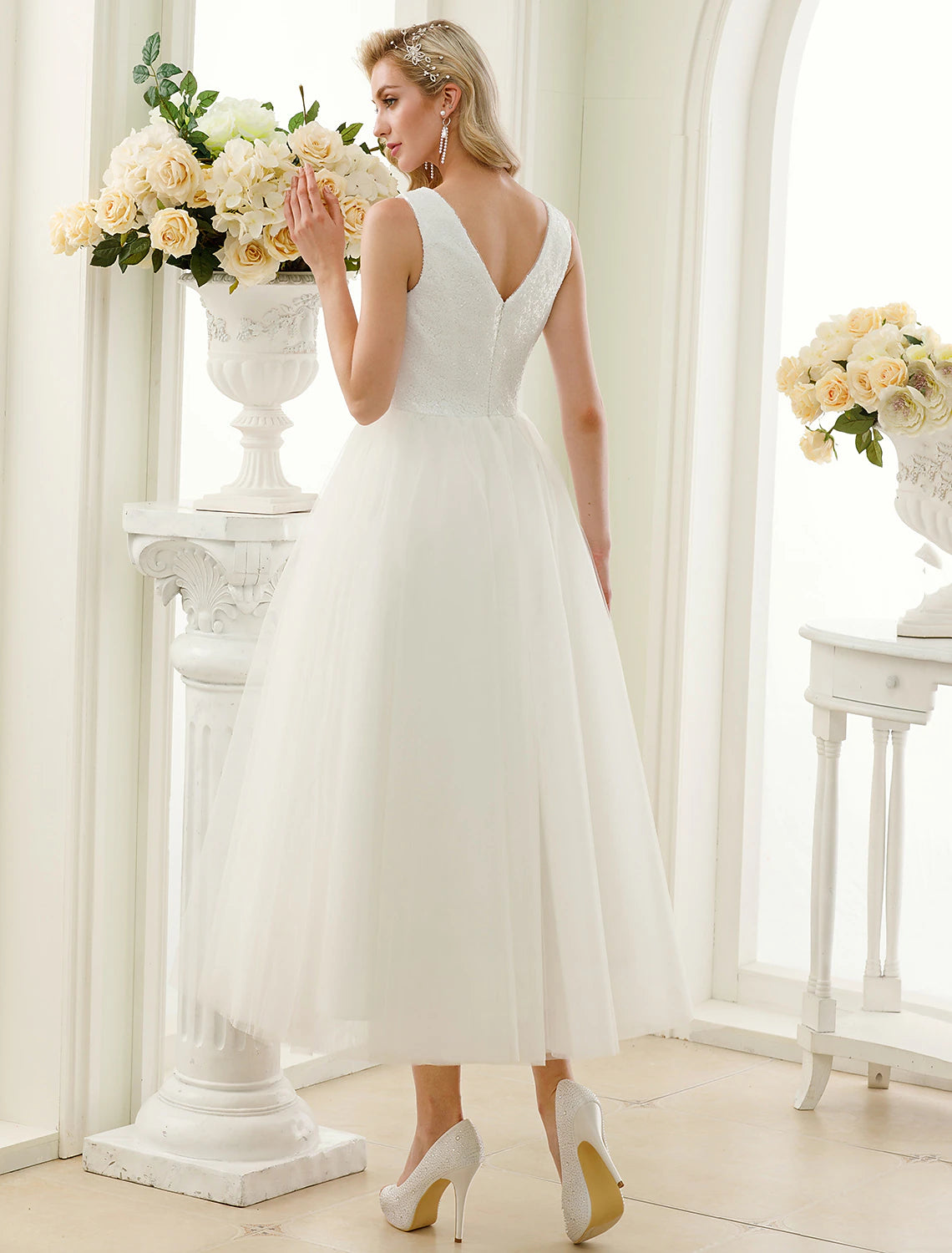 Back view of A-line tea length white wedding dress.