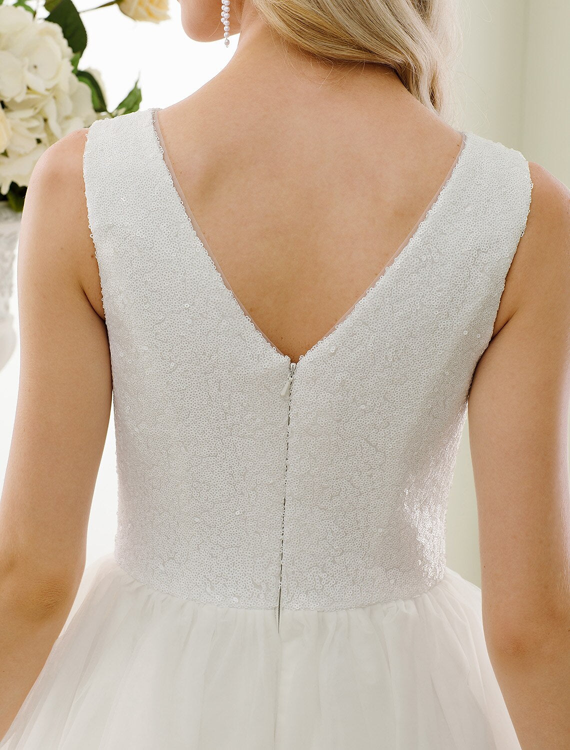 Side view of sleeveless tea length bridal gown.