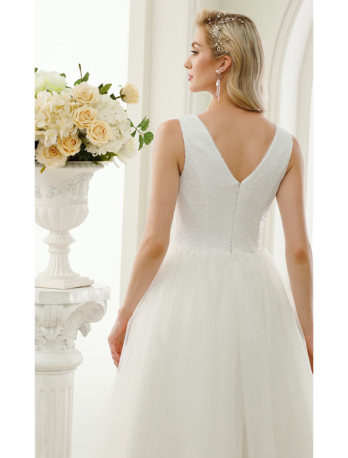 Model wearing sparkling white reception dress.