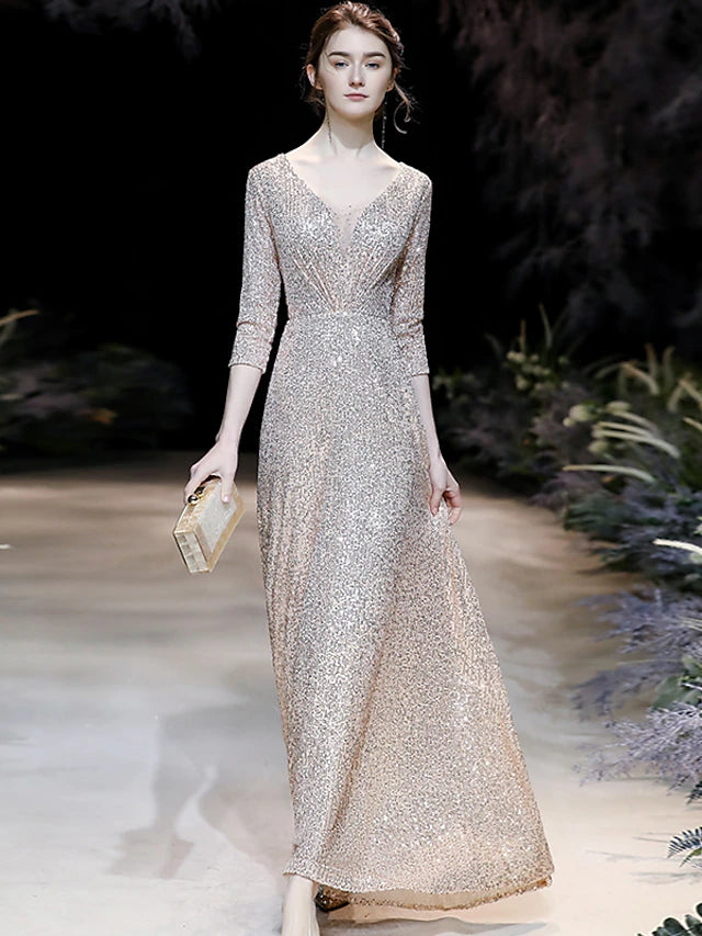 Woman wearing a sparkling A-line V-neck prom dress with 3/4 sleeves and sequins.